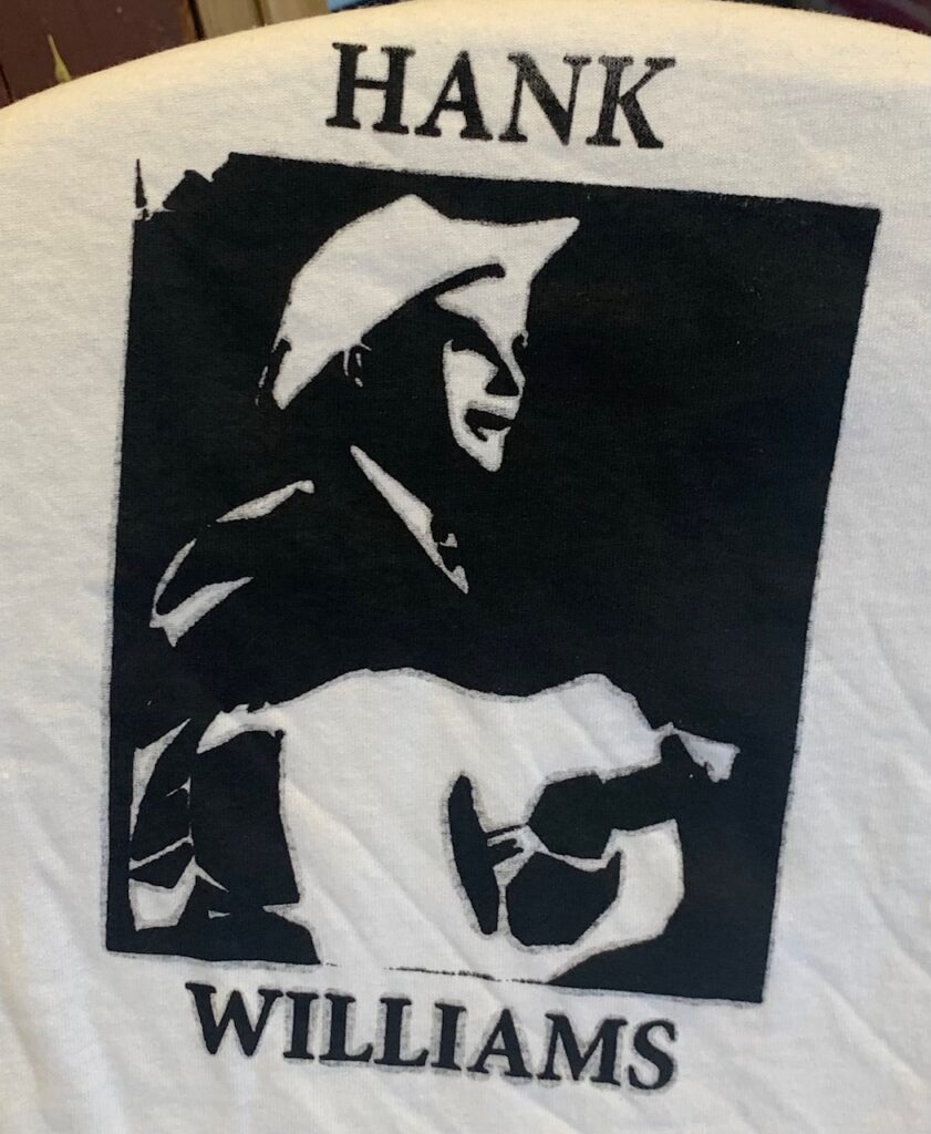 Screen print of "Hank Williams" in black serif, with a image of Hank Williams made from white negative space in black square